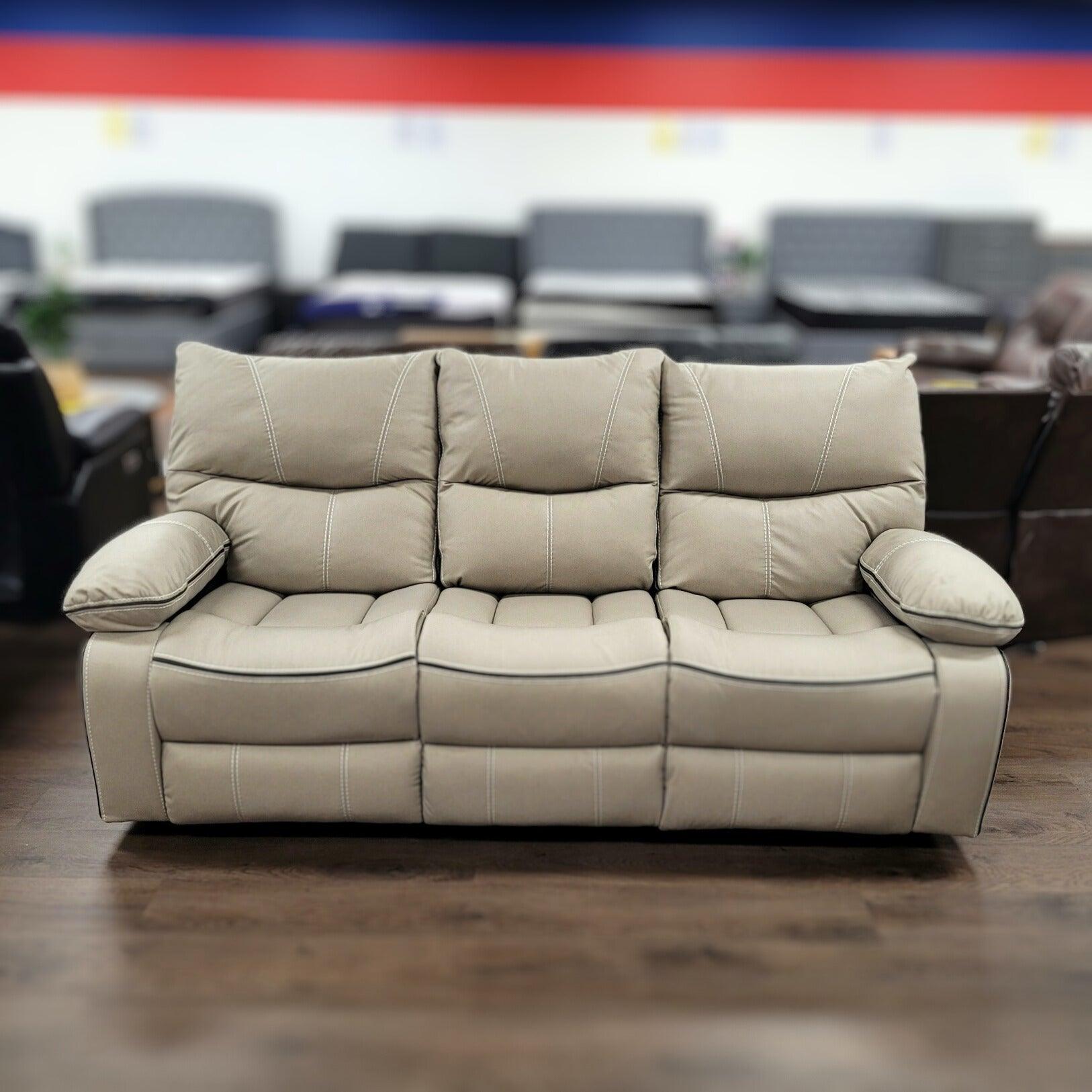Beige three-seater recliner sofa with plush cushions in a furniture showroom