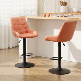 Cairo Bar Stools in orange with quilted backrests and black gas lift bases at a timber breakfast bar