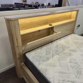 Close-up of the Canberra gas lift bed frame headboard with one push-open storage compartment open, showing the flush USB port and LED-lit shelf above - The A2Z Furniture showroom