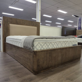 Cannon Gas Lift Bed Frame in walnut finish with slatted headboard and footboard, styled with a mattress and bedding in The A2Z Furniture showroom. Mattress and bedding shown are not included.