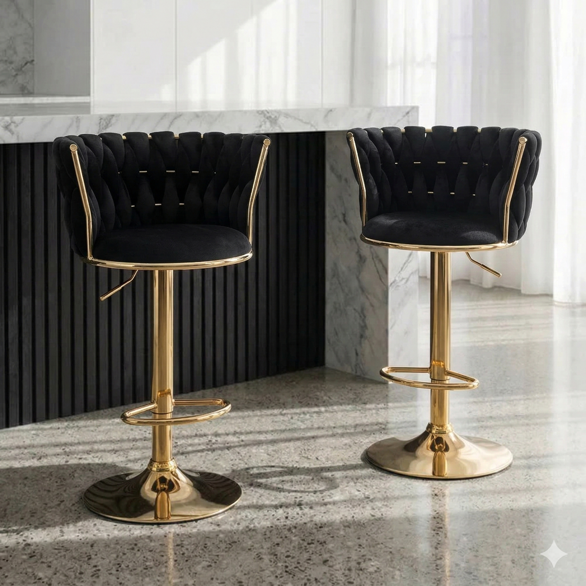 Two black bar stools with gold bases in a modern kitchen setting.