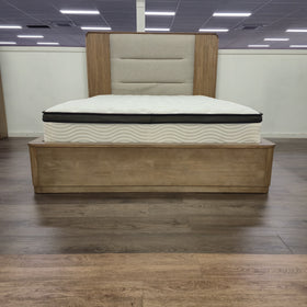 Castle Bed Frame in a natural timber finish on display in The A2Z Furniture showroom, showing the solid panelled base and plinth at the foot of the bed. Mattress shown is not included.