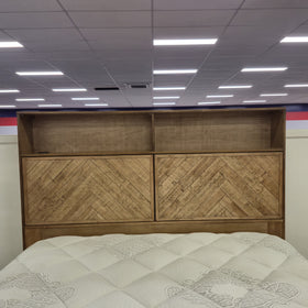 Close detail of the Cleveland Bookcase Bed Frame headboard shelving and herringbone parquet door panels in a light natural timber finish, in The A2Z Furniture showroom.
