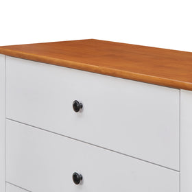 White dresser with wood top and black knobs, modern bedroom furniture close-up