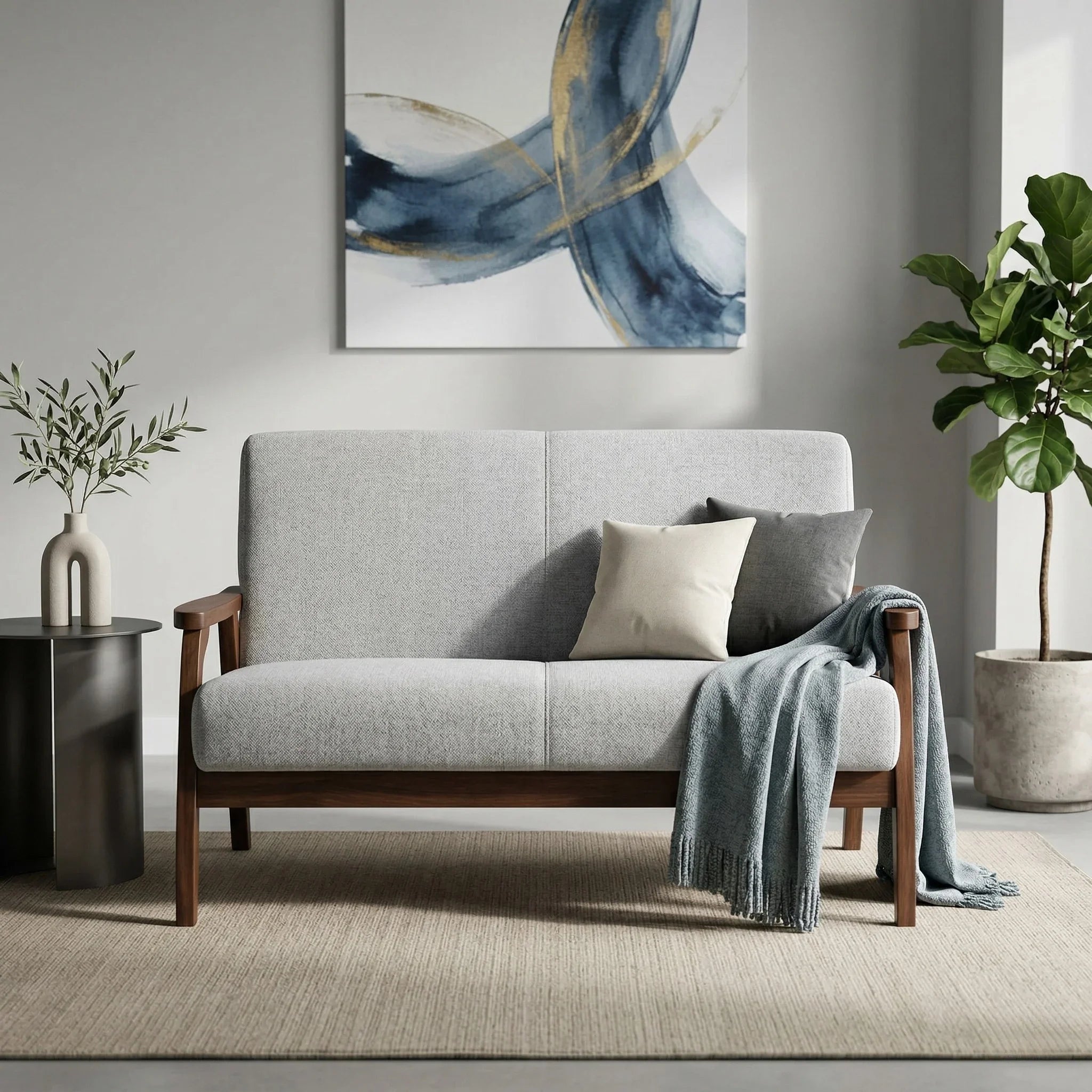 Donald 2 Seater Fabric Sofa in light grey with wooden frame, styled with cushions and throw in a modern living room setting featuring abstract wall art and indoor plants.