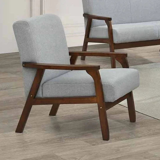 Gray cushioned armchair with wooden frame on a wooden floor