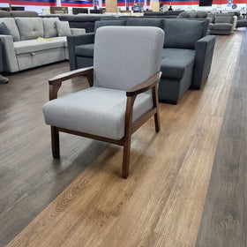 Donald Arm Chair in light grey shown from a three-quarter angle, showing the curved timber armrests and angled timber legs, in The A2Z Furniture showroom