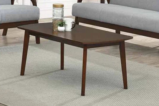 Wooden coffee table in a living room setting with gray sofa and rug.