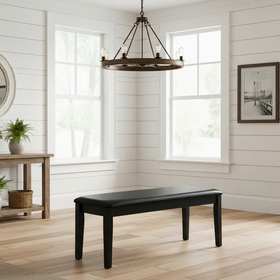 Black bench in a room with wooden floor, white walls, and a mirror.