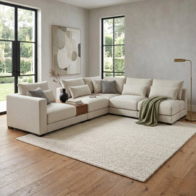 Modern living room with a beige sectional sofa, wooden coffee table, and decorative elements.