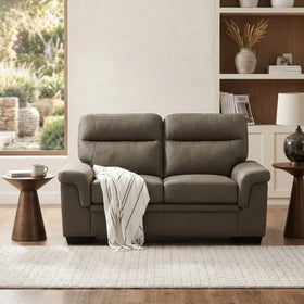Erika 2 Seater Fabric Sofa in gray with plush cushions and a cozy throw blanket, placed in a modern living room with natural light and wooden side tables.