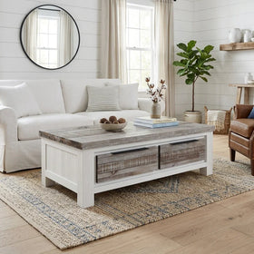 Living room with a white sofa, wooden coffee table, and decorative items.