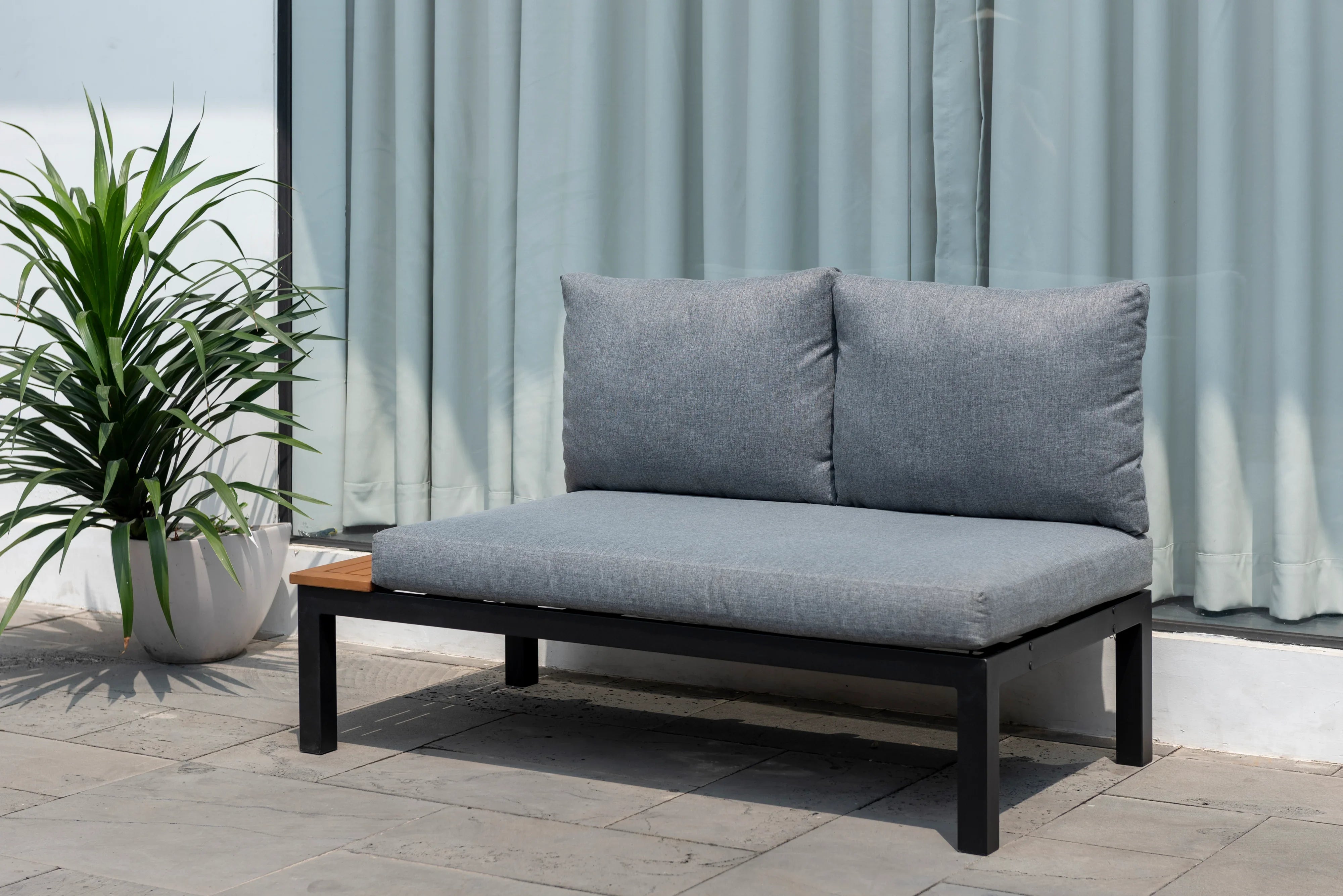 Modern grey 2-seater outdoor sofa with metal frame and potted plant on patio
