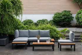 Modern outdoor patio sofa set with grey cushions and wooden coffee table in garden setting