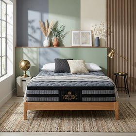 Cradle Rest 5 Zone Pocket Spring Mattress displayed on a wooden bed frame with cushions, soft natural lighting, and minimalist modern bedroom decor.