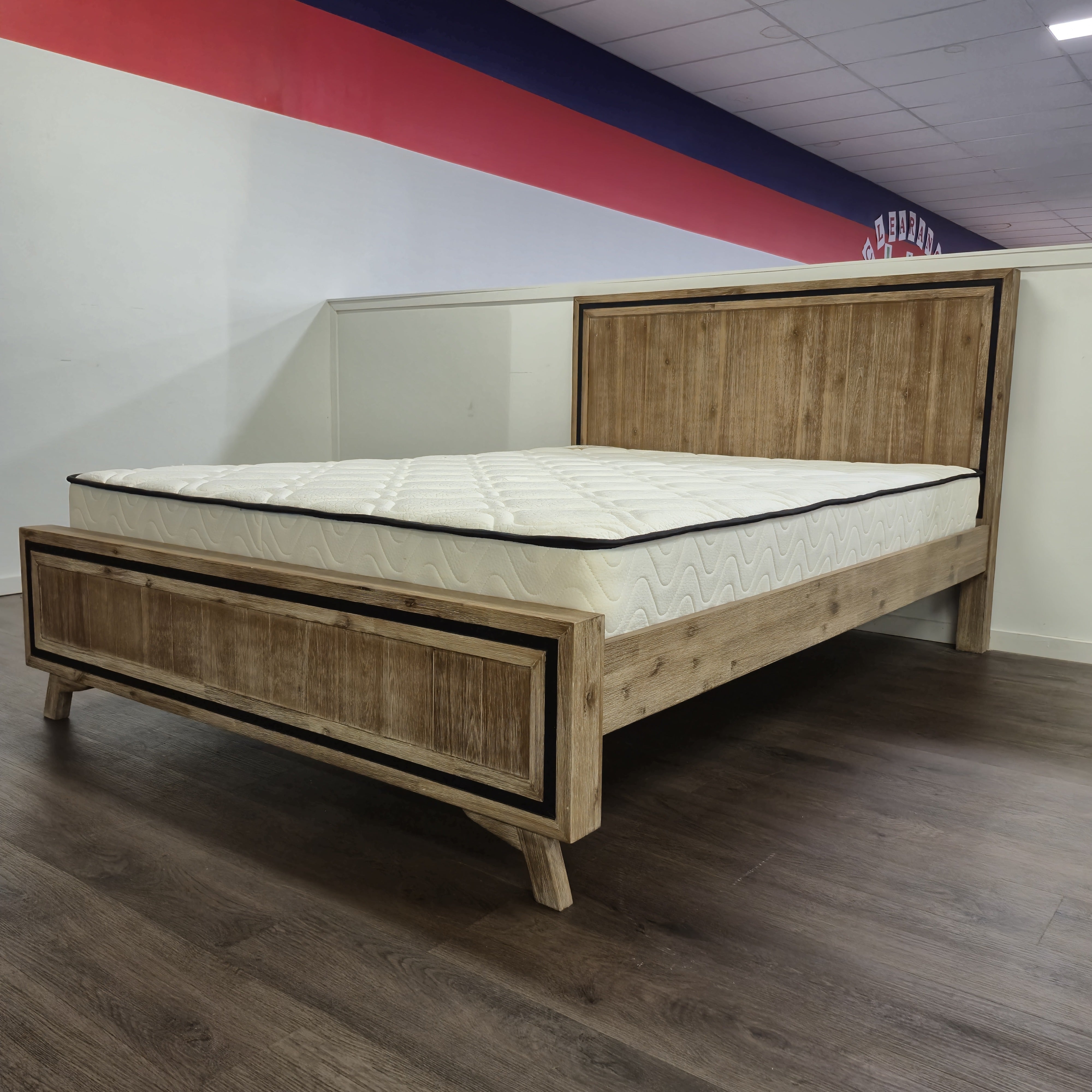 Jack Acacia Bed Frame angled view in natural acacia timber with black trim edge, shown on display in The A2Z Furniture showroom (mattress shown not included)