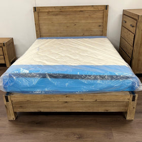 Rustic wooden bed frame with headboard, new mattress in plastic, bedside table and tall dresser
