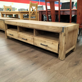 Natural wood TV unit with drawers and open shelves in a showroom setting