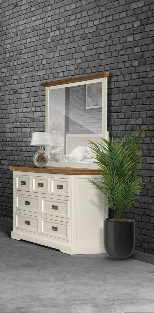 White dresser with wooden top against a gray brick wall