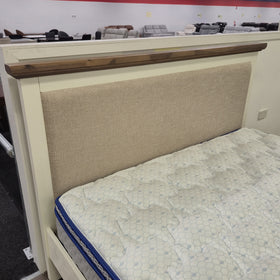 Close-up of the Jericho II Bed Frame with Storage headboard corner, showing the walnut-toned timber top rail, cream painted frame joinery and oatmeal upholstered panel