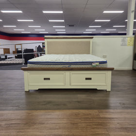 Jericho II Bed Frame with Storage, straight-on front view showing the upholstered headboard, two closed storage drawers in the footboard base and a mattress on top (mattress not included), in The A2Z Furniture showroom