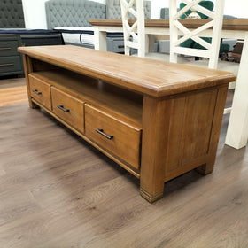 Josh TV Unit in natural wood finish featuring three drawers with metal handles and an open shelf, designed for modern living room storage and display needs.