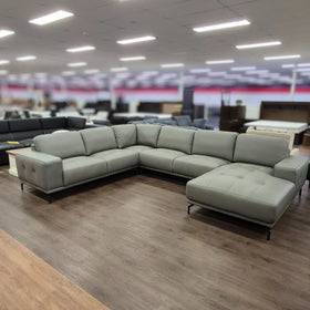 Modern grey corner leather lounge with chaise in spacious showroom