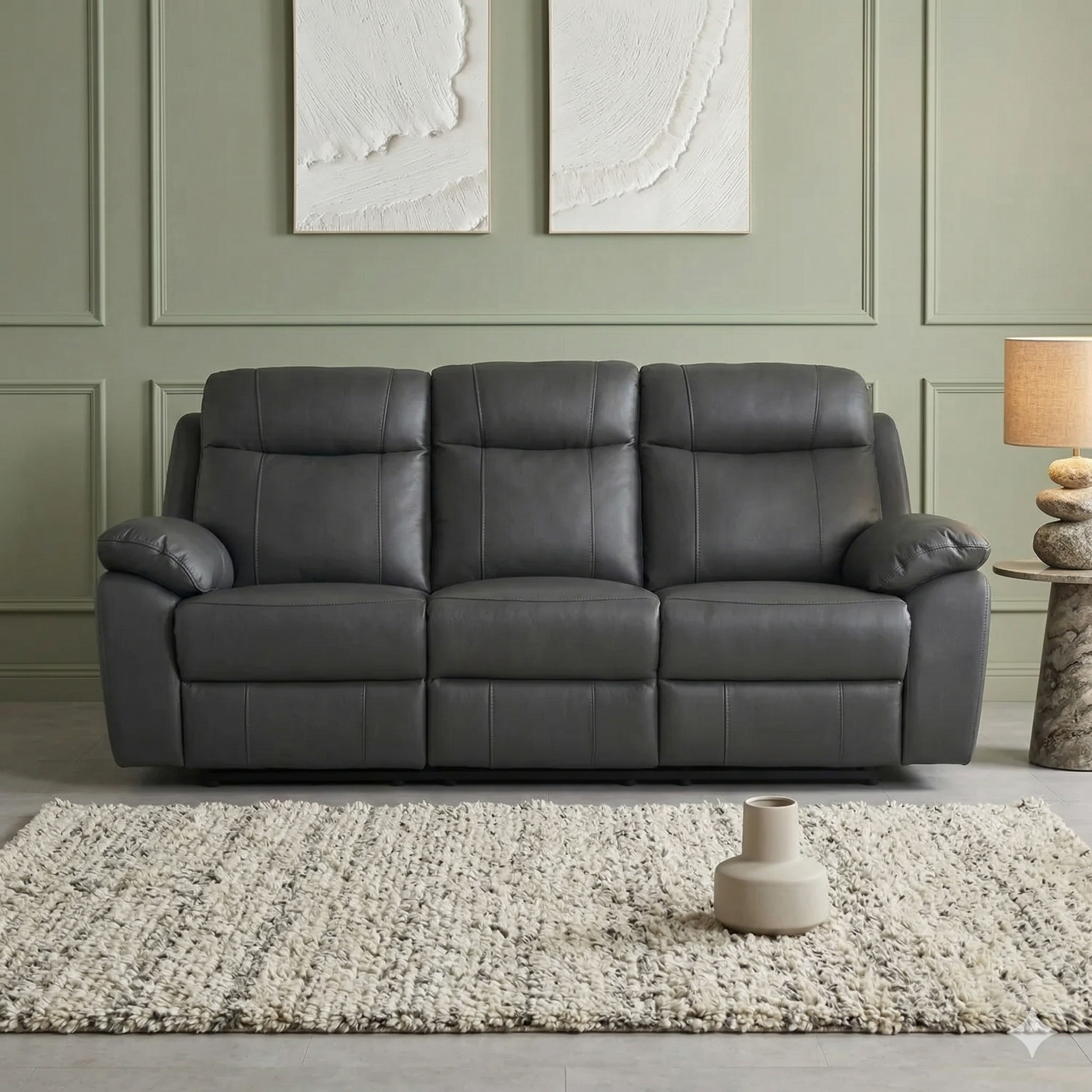 Gray leather sofa in a living room with a textured rug and abstract art on the wall.