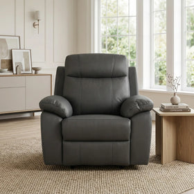 Latrobe Leather Recliner Chair in dark gray leather with plush cushioning, set in a bright living room featuring a wooden side table and minimalist decor.