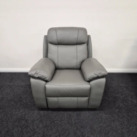Grey leather single recliner armchair with padded arms and backrest on dark carpet