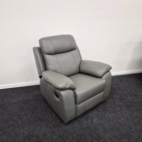 Grey leather recliner armchair with padded cushions on a dark carpeted floor