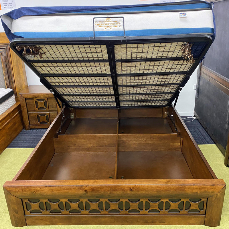 Image of The A2Z Furniture's Lilly bed - a wooden bed frame with gas lift storage drawer, available in queen and king sizes, with a traditional carved headboard design.