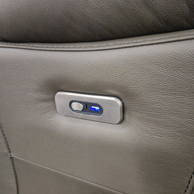Close-up of the brushed metal control panel on the Limestone Swivel Electric Leather Recliner Chair, with electric recline button, USB-C port and illuminated USB-A charging port set into the leather arm