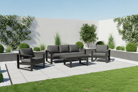 Garden furniture set with sofa and chairs on a patio area with greenery.