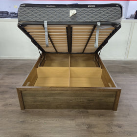 Marina gas lift bed frame with the base lifted open showing the slatted lift mechanism and divided under-bed storage cavity - The A2Z Furniture showroom