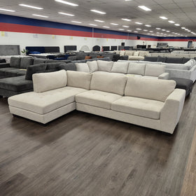 Melton 3 Seater Chaise Lounge in Galaxy Natural photographed front-on in the showroom, showing the full seat width and tufted cushions.