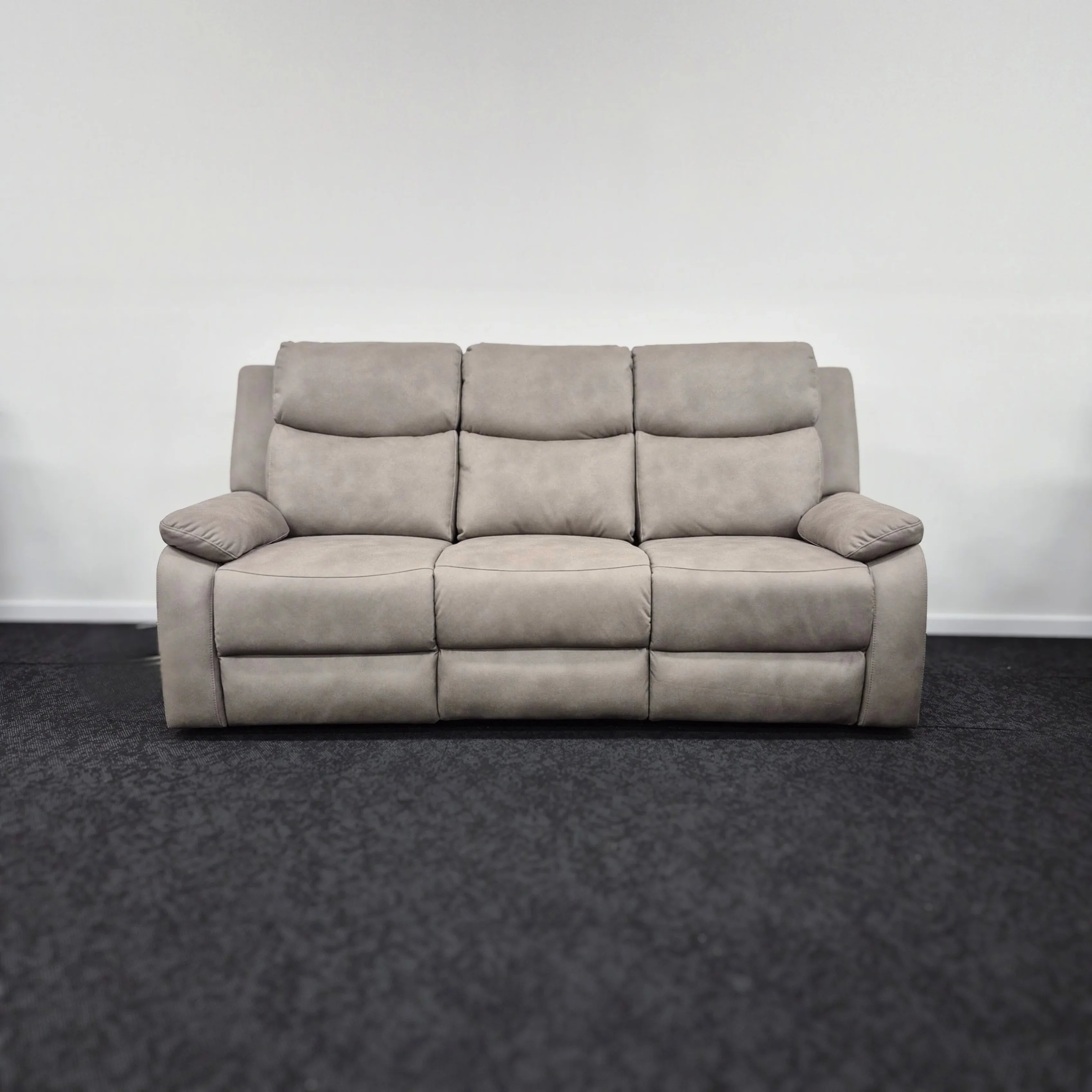 Modern grey 3 seater fabric sofa with plush cushions in showroom setting
