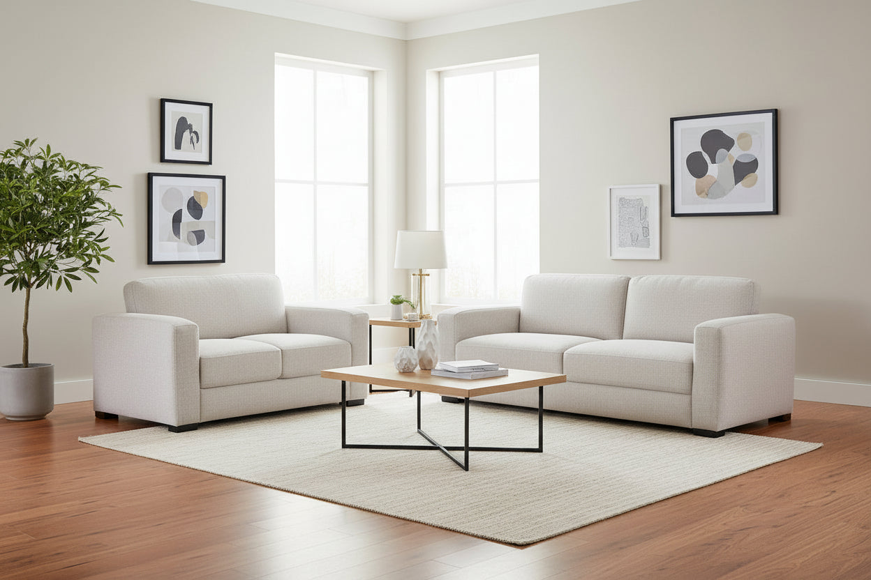 Modern living room with white sofas, a coffee table, and decorative elements.