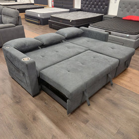 Oasis Pull Out Sofa Bed in dark grey fabric laid flat in bed mode with the back cushions removed, at The A2Z Furniture showroom
