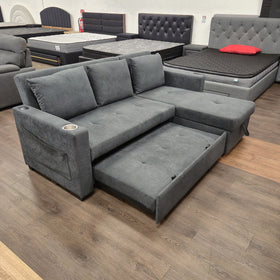 Oasis Pull Out Sofa Bed in dark grey fabric with the pull-out bed partly drawn out, angled view at The A2Z Furniture showroom