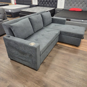 Oasis Pull Out Sofa Bed in dark grey fabric viewed from the rear three-quarter angle in sofa mode, at The A2Z Furniture showroom