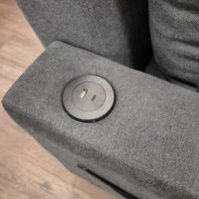 Close-up of the USB-A and USB-C charging port set into the arm of the Oasis Pull Out Sofa Bed in dark grey fabric