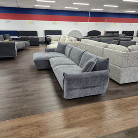 Opal L-shaped fabric lounge with chaise in dark grey, side profile showing the low back height and chaise depth, in The A2Z Furniture showroom