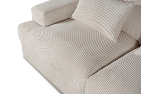 Beige corduroy fabric sofa with wide armrest and matching textured cushion
