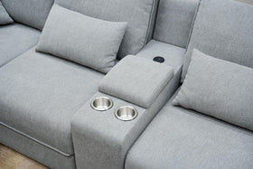 Modern light grey fabric sofa with cup holders and cushions, lounge furniture detail