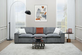 Modern living room with grey corduroy sofa, glass coffee table and contemporary decor