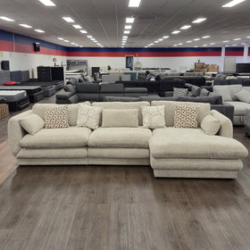 Otway L-Shaped Fabric Lounge in Beige on display in The A2Z Furniture showroom, photographed front-on with the chaise on the right when sitting.