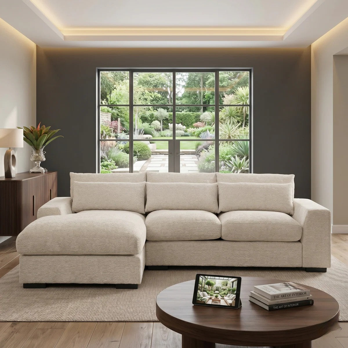 Oxford 3 Seater Couch with Chaise in a bright modern living room with large window overlooking a garden, featuring beige upholstery and plush cushions on a neutral rug.