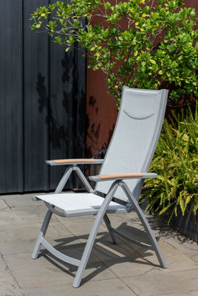 Modern grey outdoor reclining chair with mesh seat and armrests on patio