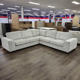 Pavillion L-shaped fabric sofa in silver viewed from the corner with both arms closed, in The A2Z Furniture showroom